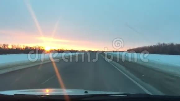 汽车在公路上行驶冬季运动雪阳光日出视频的预览图