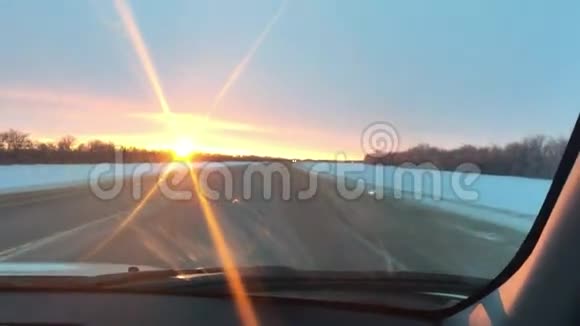 汽车在公路上行驶运动冬季雪地阳光日出旅行视频的预览图