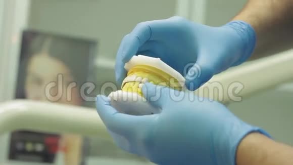 牙科医生展示男性患者的人类颌骨模型并讨论牙科问题视频的预览图