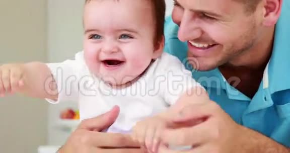 微笑的父亲挠着他的孩子视频的预览图