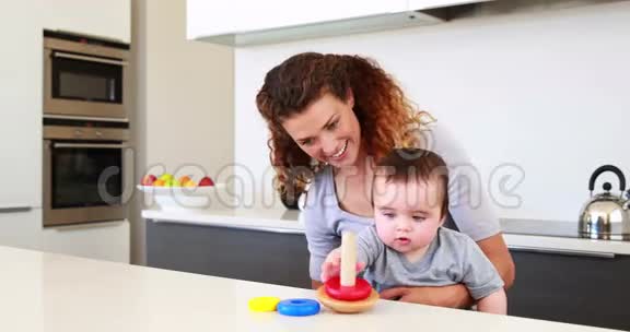 快乐的妈妈和小男孩坐在一起玩木玩具视频的预览图