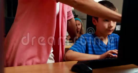 老师在计算机课上帮助小男孩视频的预览图