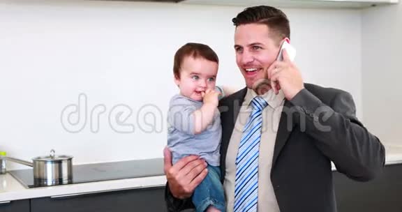 父亲在工作前抱着他的儿子打电话视频的预览图