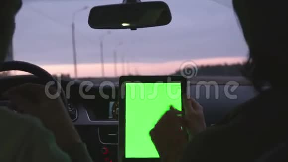 两个人坐在现代的车里用绿色的屏幕在平板电脑上讨论这条路线视频的预览图