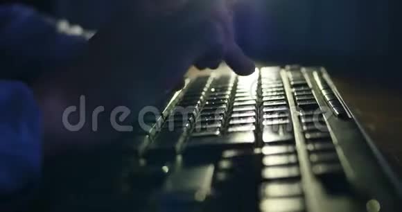 晚上在键盘上打字暗色背景照明特写视频的预览图
