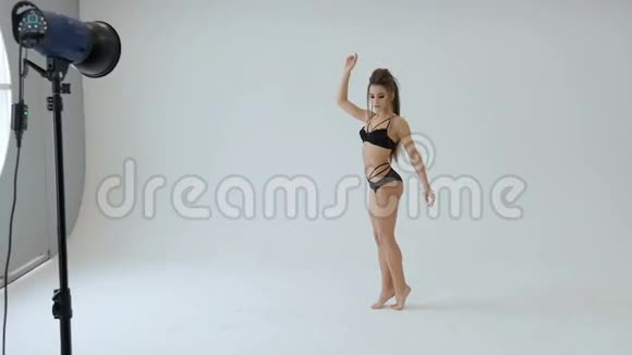 穿着黑色蕾丝内衣的漂亮女孩在白色工作室跳舞视频的预览图