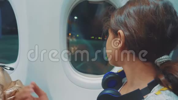 少女航空飞机概念年轻的女孩看着外面的生活方式坐在窗边的飞机夜间飞行视频的预览图