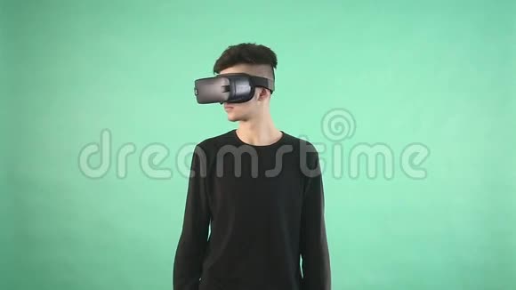 在绿色背景下使用虚拟眼镜的年轻人视频的预览图