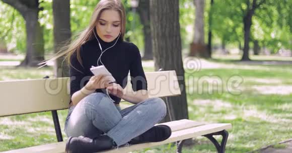 坐在长凳上听音乐的女人视频的预览图