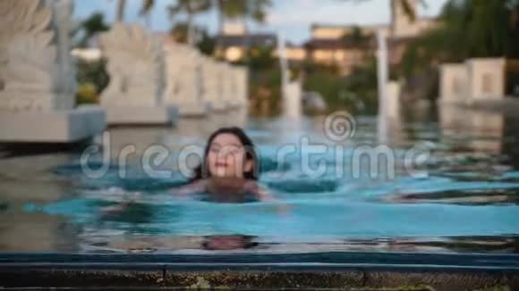 漂亮的女人在游泳池里游泳视频的预览图