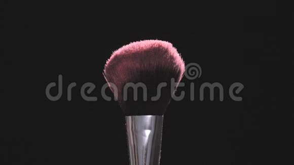 在黑色背景上用粉色粉末做的化妆刷慢动作视频的预览图