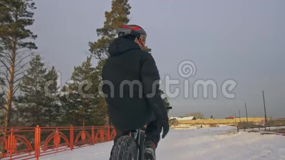 专业的极限运动运动员骑胖自行车在户外骑自行车在冬天的雪田森林人类视频的预览图