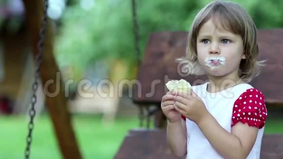 小女孩坐在长凳上吃冰淇淋视频的预览图