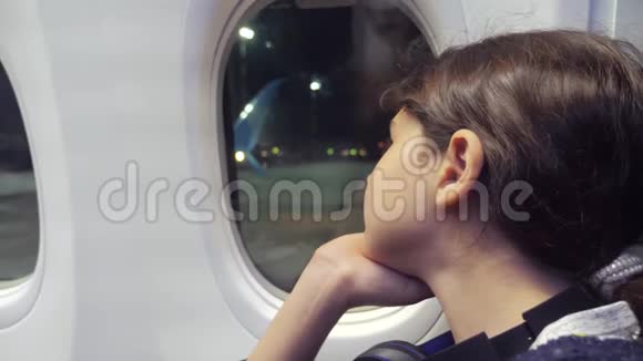 少女航空飞机概念年轻女孩看着坐在窗边的飞机夜间飞行生活方式视频的预览图
