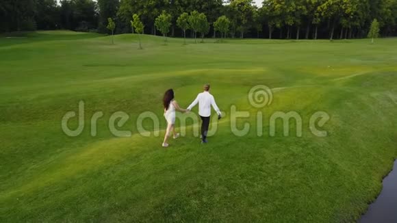 在夏季公园散步的年轻夫妇的鸟瞰图环龙射击男女视频的预览图
