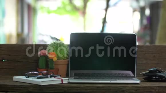带笔记本电脑的木桌大树下的户外工作场所视频的预览图