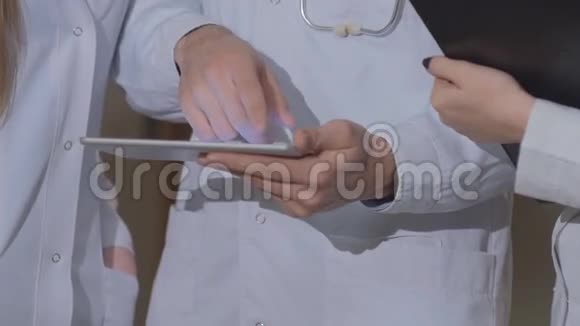 医生和同事一起检查平板心脏造影视频的预览图