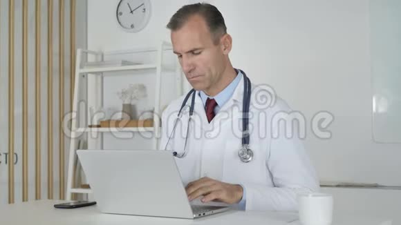 医生在诊所的笔记本电脑上打字视频的预览图