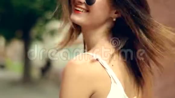年轻的金发碧眼的红唇和太阳镜走在街上视频的预览图