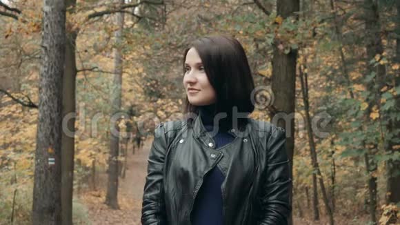 在秋天公园散步的年轻美丽的女人秋天在森林里散步的女孩的生活方式概念视频的预览图