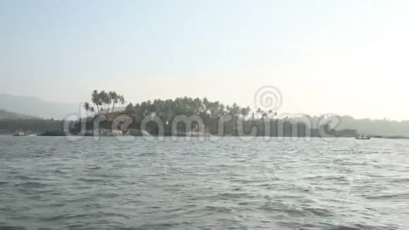 日落时分从海边看岛屿靠近海滩棕榈视频的预览图