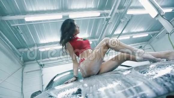 穿着红色西装戴着泡沫摆在车罩上的女人视频的预览图