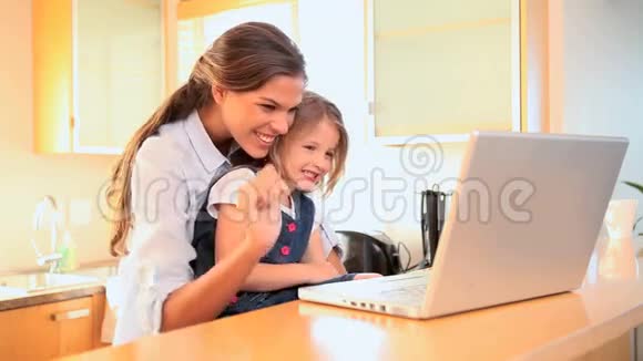 妈妈和女儿在笔记本电脑上看视频视频的预览图