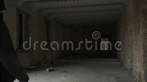 肮脏的流浪汉拿着垃圾袋在废弃的大楼里散步视频的预览图