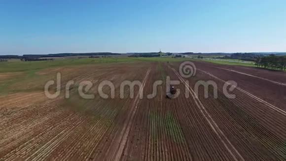 4K空中飞行用现代马铃薯挖掘机拖车和拖拉机收割马铃薯视频的预览图