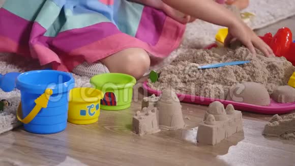 手可爱的金发小女孩在工作室玩沙子近点视频的预览图