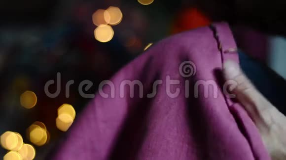 紧密的双手缝合柔和的粉红色织物与舒适发光的背景视频的预览图