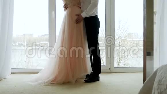 丈夫抱着怀孕的妻子的肚子穿着衣服视频的预览图