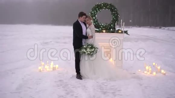 冷冻湖壁炉附近的新婚夫妇视频的预览图