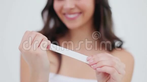 微笑的黑发女人整理她的指甲视频的预览图