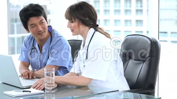 两个认真的医生在看手提电脑视频的预览图