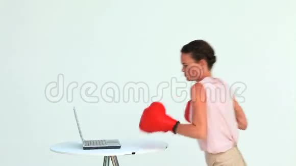 女商人戴着拳击手套打手提电脑视频的预览图