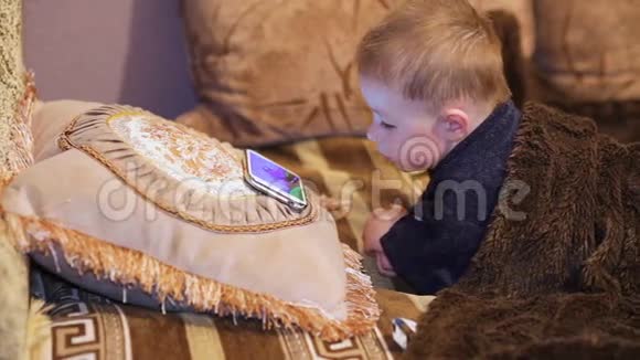 小男孩在智能手机上看卡通视频的预览图