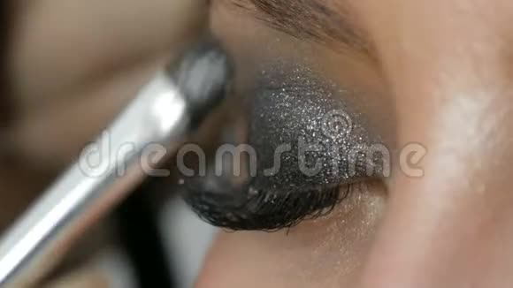 专业的高级时装化妆师用特殊的灰色眼影眼睛和眼睛制作出烟熏眼视频的预览图