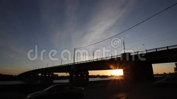 日落时桥梁和道路交通视频的预览图