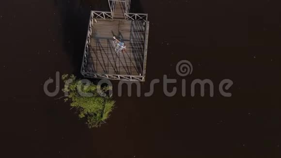 一个年轻的女人在河边用平板电脑空中射击视频的预览图