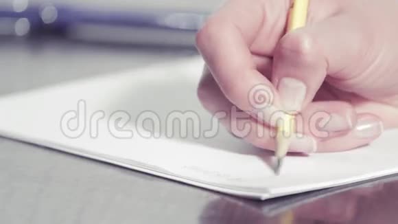 女人用铅笔写字的手视频的预览图