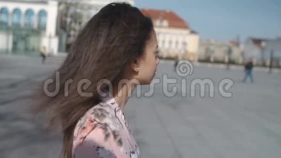 一位年轻女子在城市街道上行走的肖像视频的预览图