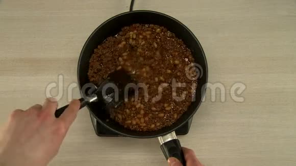 在烹饪过程中观看烹饪搅动豆子和肉视频的预览图