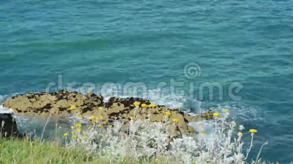 在阳光明媚的夏日爱尔兰威克斯福德爱尔兰海岸线上的岩石上波浪轻轻破碎视频的预览图
