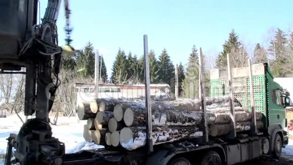 原木货代慢慢地从绿色卡车上卸下原木视频的预览图