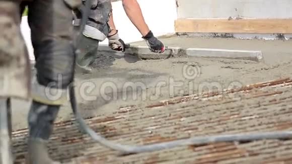 穿着工作靴和头套的男人用水泥压平视频的预览图