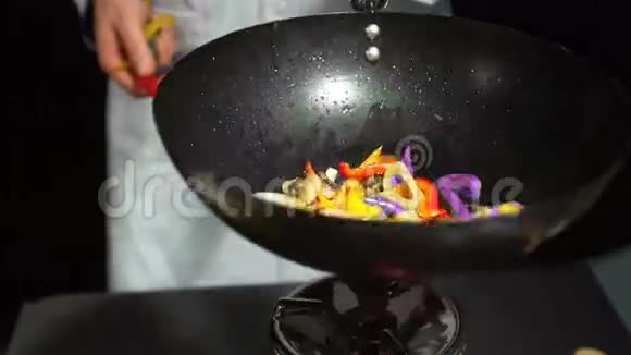 厨师把混合蔬菜扔进锅里视频的预览图