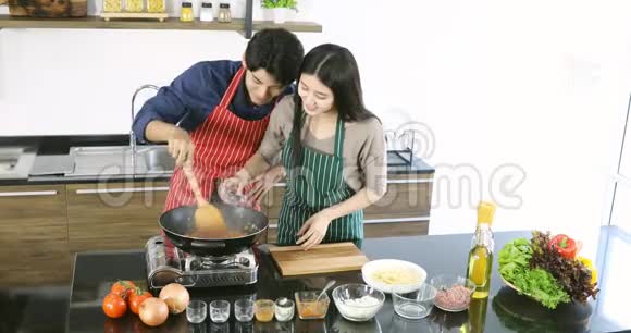 亚洲夫妇一起在厨房做饭视频的预览图