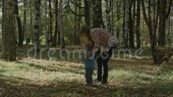 秋天妈妈和儿子在户外散步视频的预览图