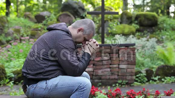 在户外教堂人们拿着念珠在长凳上祈祷视频的预览图